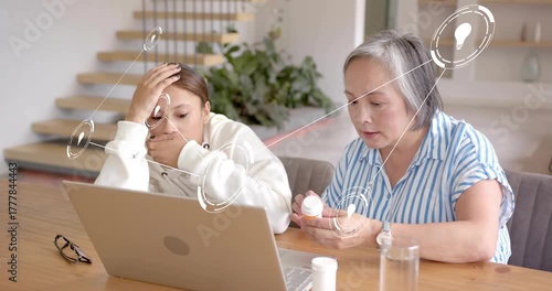 Mother reaching for pill bottle and explaining dosage info to daughter, showing medical graphics