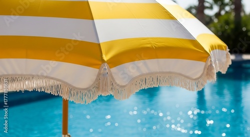 Guarda-sol amarelo e branco à beira da piscina em dia ensolarado