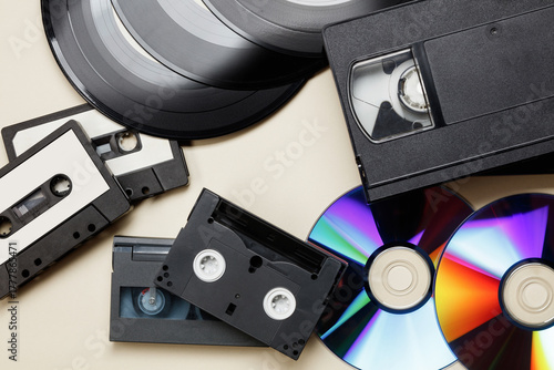 Texture of vintage retro vinyl records, retro acoustic, audio cassette tape, black video tape cassette, CD disc. Saving data, music, movies, videos. Vintage media concept. Top view. 