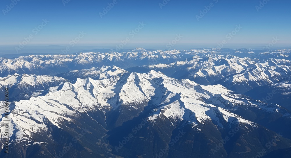 Obraz premium Breathtaking Aerial View of Vast Snow capped Mountain Range on Sunny Day