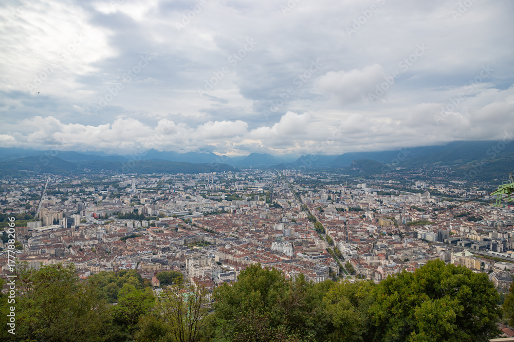 Obraz premium Aerial view of Grenoble old town seen from Bastille Fort, Auvergne-Rhone-Alpes region, France, Europe. View from above on the Isere Valley in the French Pre-Alps. Chartreuse Belledonne mountain range