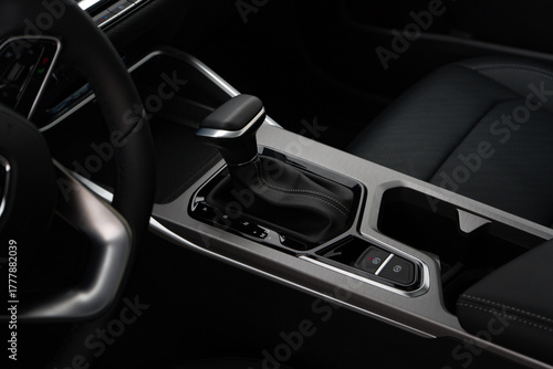 Car interior indoor. Black leather automatic gearbox with chrome button