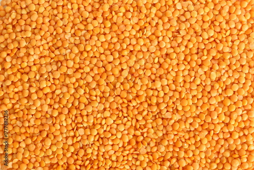 Texture of yellow lentils scattered on the surface.