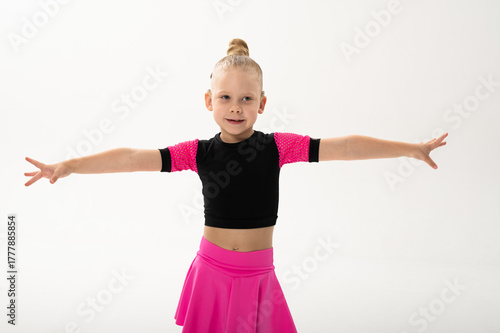 Young dancer with cochlear implant extending arms gracefully. Expression of inclusion, sound awareness, and emotional freedom through art and rhythmic discipline.