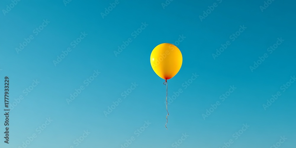 Obraz premium Single Yellow Balloon Rising in Pristine Blue Sky Minimal Inspiration 