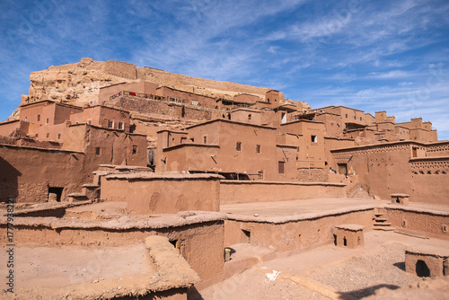 Close-up view of the traditional mudbrick architecture of Aït Benhaddou, Morocco, showcasing the earthen buildings clustered together under a bright blue sky.