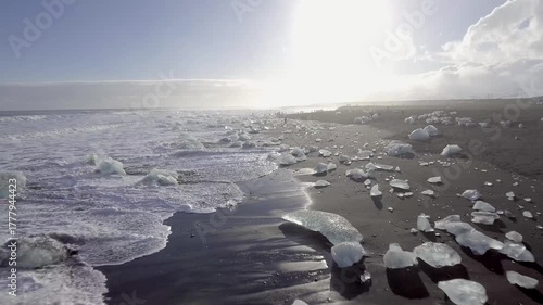 Aerial view of black sand beach with iceberg ice pieces on the shore also called diamond beach
