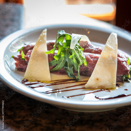 carpaccio de res con láminas de queso parmesano