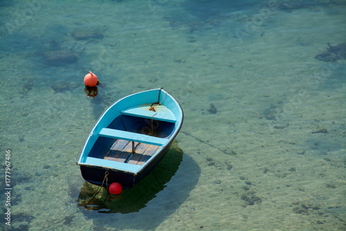 Solitary blue boat in crystal clear turquoise water
