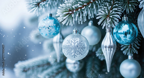 Christmas ornaments hang from a frosted pine branch in winter. A serene, festive closeup brings holiday cheer. Winter holidays, holiday season, magical winter.