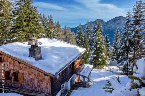 traditional wooden chalet or cabin nestled on a snowy slope, in the Austrian Alps
