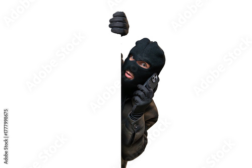 Obraz na plátně Thief wearing a black balaclava and gloves, peeking from behind a white banner w