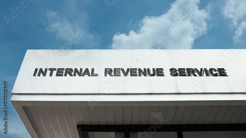 Internal Revenue Service word sign prominently displayed on the official government building facade beneath a clear blue sky, signifying the national agency responsible for collecting taxes