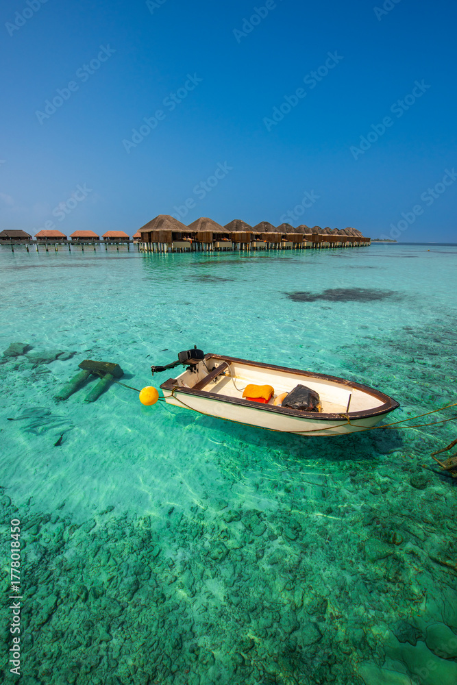 Fototapeta premium Tranquil closeup calm sea water waves with palm trees. Boat and bungalows background. Tropical island beach landscape exotic shore coast. Summer vacation, holiday amazing nature, Maldives.