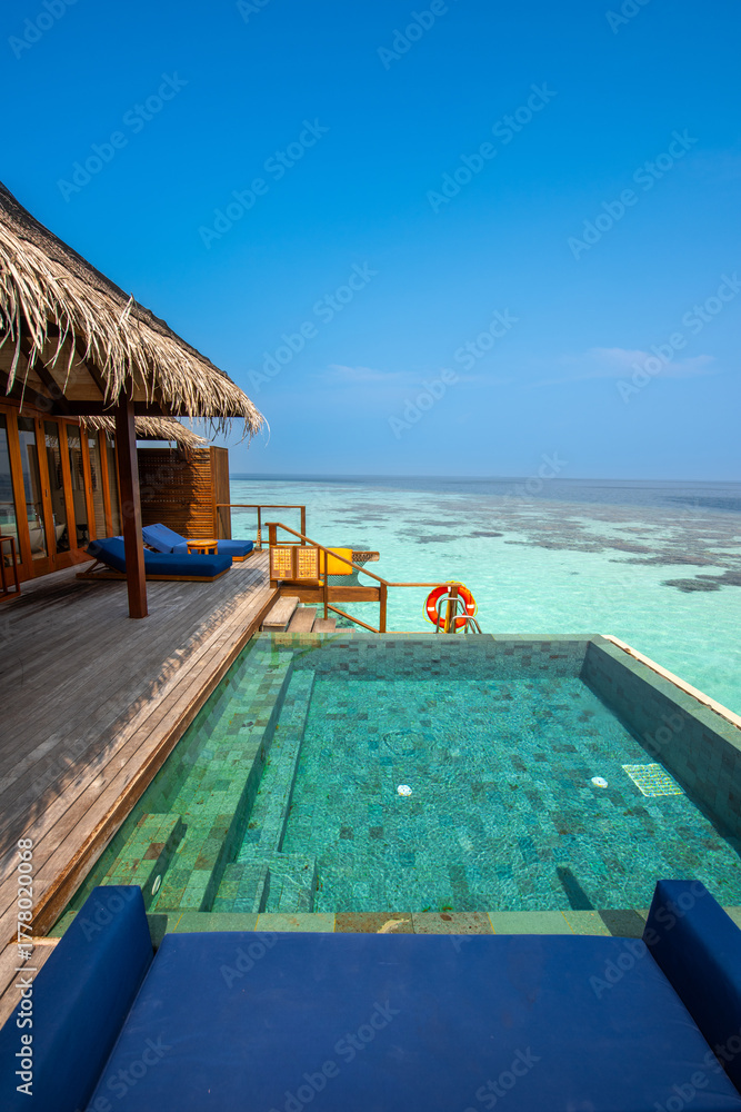 Fototapeta premium Tranquil closeup calm sea water waves with palm trees. Cabin with pool. Tropical island beach landscape exotic shore coast. Summer vacation, holiday amazing nature. Relax paradise, Maldives.