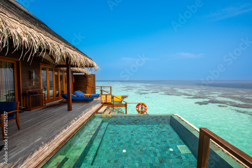 Tranquil closeup calm sea water waves with palm trees. Cabin with pool. Tropical island beach landscape exotic shore coast. Summer vacation, holiday amazing nature. Relax paradise, Maldives.