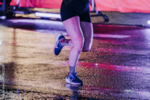 Photography Night marathon runners crowd in the rain, sportsmen participants start running t