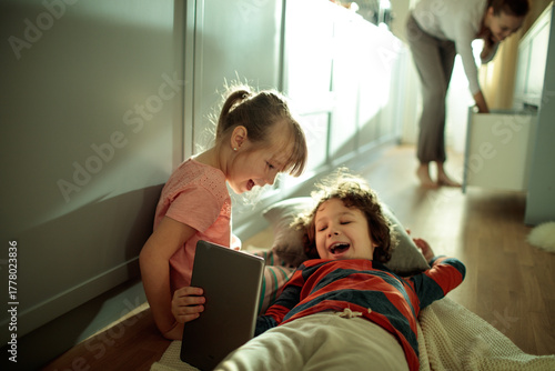 Young children playing with tablet at home