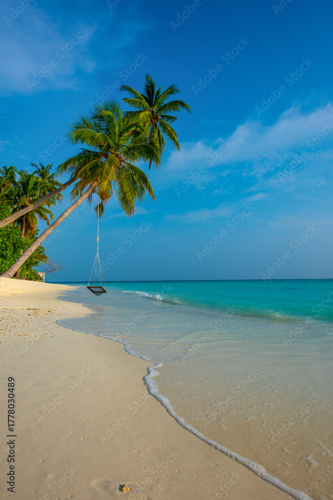Fototapeta premium Tranquil closeup calm sea water waves with palm trees. Swing on the tree. Tropical island beach landscape exotic shore coast. Summer vacation, holiday amazing nature. Relax paradise, Maldives.