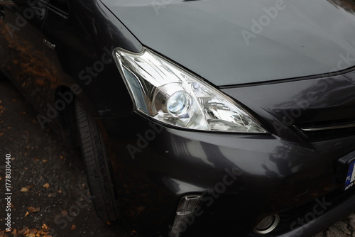 Headlight of a black car, close-up view, automobile trade and production. Xenon lamp.