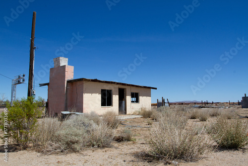 Abandoned structure made from hollow cinder blocks of concrete with a fireplace and chimney in the middle of the desert