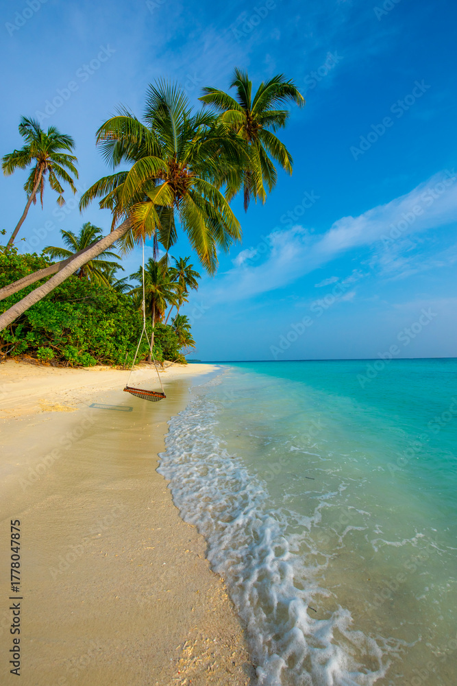 Fototapeta premium Tranquil closeup calm sea water waves with palm trees. Swing on the tree. Tropical island beach landscape exotic shore coast. Summer vacation, holiday amazing nature. Relax paradise, Maldives.