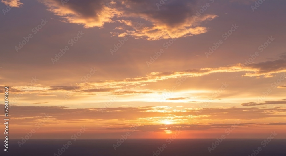 Fototapeta premium Sea sunset with radiant golden light piercing clouds over a calm sea