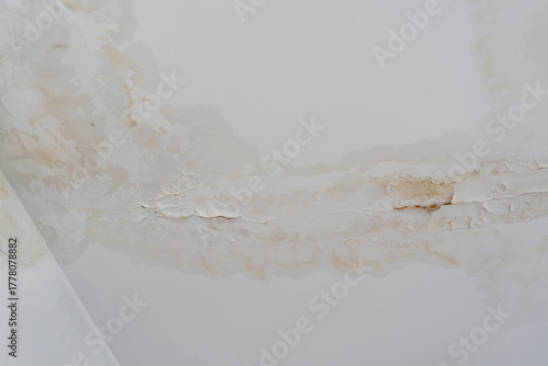Water stains on damaged ceiling. Concept of home neglect and costly consequences of hidden water leakage.