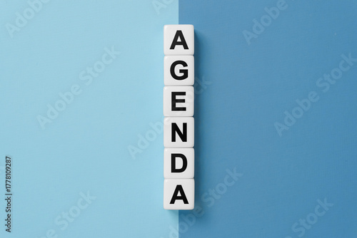 Agenda word on dice on blue and gray background