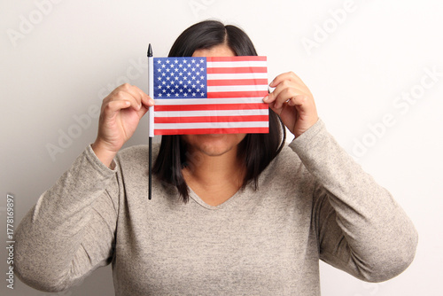 40-year-old Latina woman proudly displays the United States flag as a symbol of migration and freedom