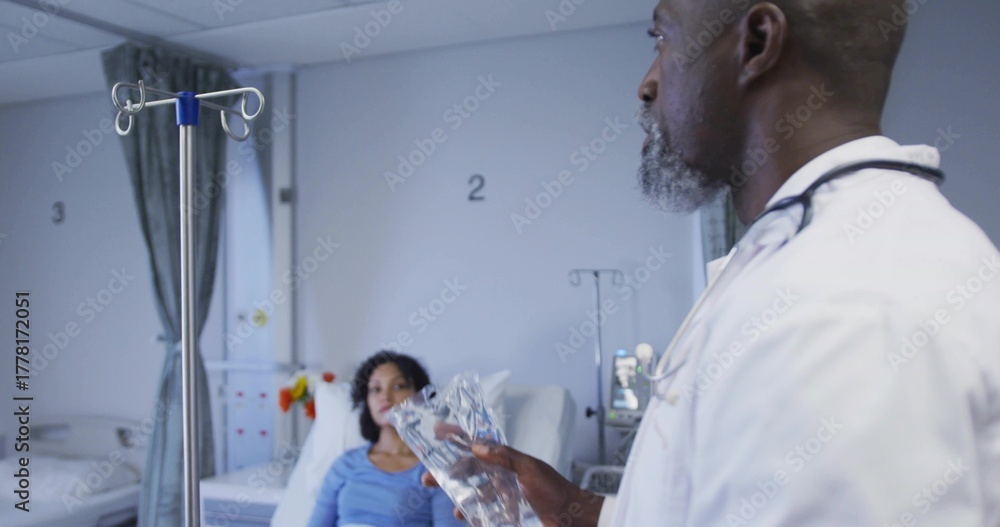 Fototapeta premium Standing physician adjusting IV fluid bag in hospital ward, with IV pole, copy space