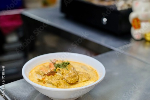 A bowl of Nyonya prawn laksa on the kitchen counter of Old Nyonya, a hawker stall at Maxwell Food Centre - downtown Singapore, near Chinatown
