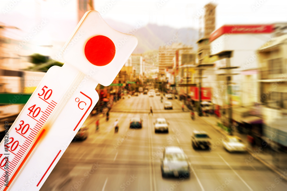 Fototapeta premium Thermometer showing high temperature against city during hot day