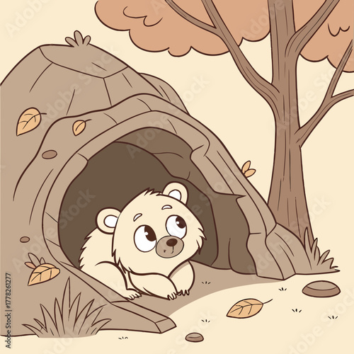 Adorable bear cub is looking out from a cozy den in the autumn forest
