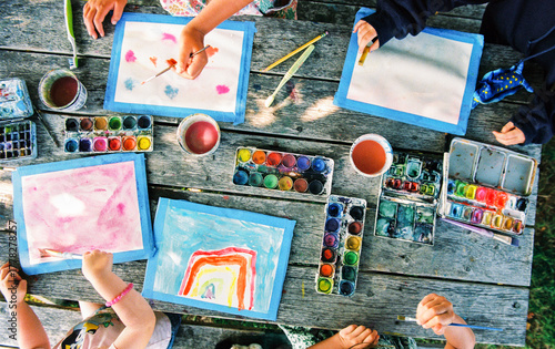 Children make art on a picnic table