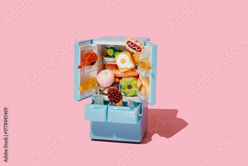 toy food spills from atoy fridge with doors open