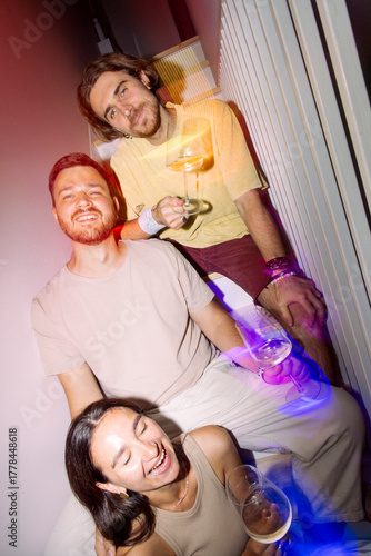 Friends Drinking Wine Together with Colorful Lights