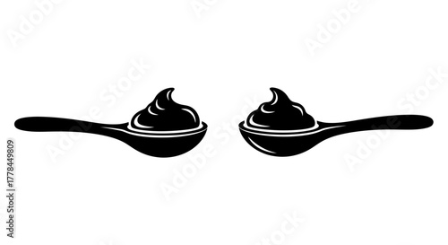 Two black spoons filled with a dark swirling creamy substance