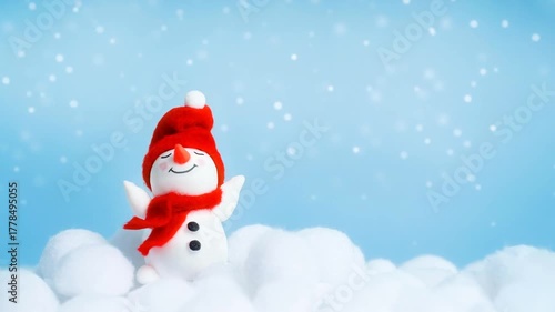 A cute snowman raises hands to the sky waves and smiles while snow is falling. Clean minimal scene with space for text. Seamless loop.