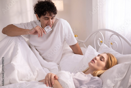 A man who wants to have sex with his wife gets sexually aroused and uses a condom.