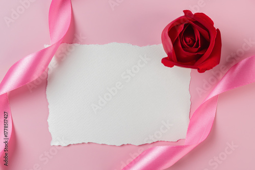 Blank paper card mockup and red roses on pink background. Valentine or wedding background.