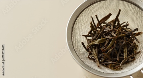 Dry loose-leaf tea in a metal mesh strainer. Natural herbal ingredients for brewing a healthy beverage with copy space for text.