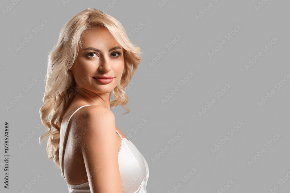 Naklejka premium Pretty young woman with curly blonde hair on white background