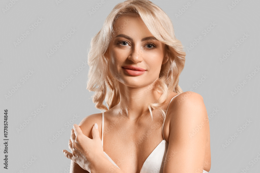 Obraz premium Pretty young woman with curly blonde hair on white background