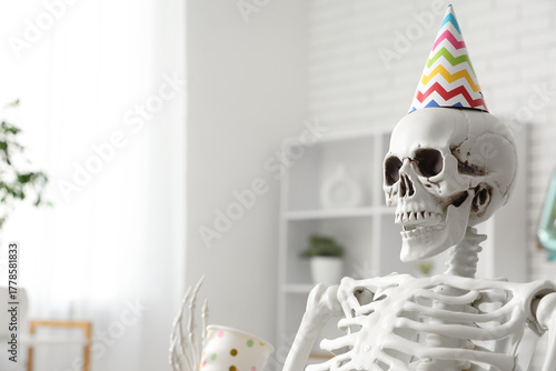 Skeleton in party hat with ...