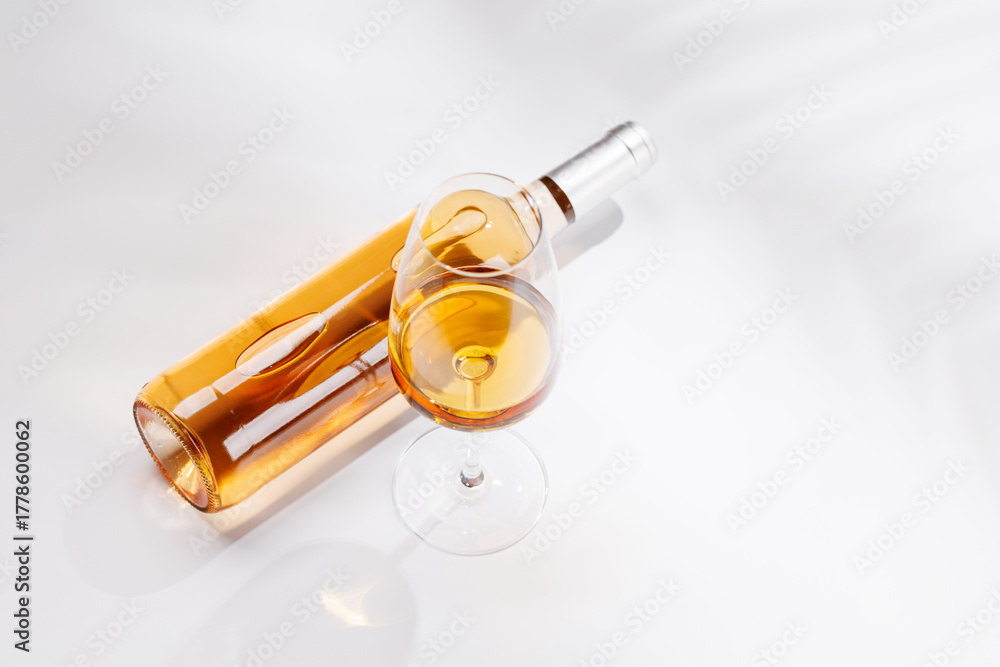 Fototapeta premium Rose wine bottle and glass on white background
