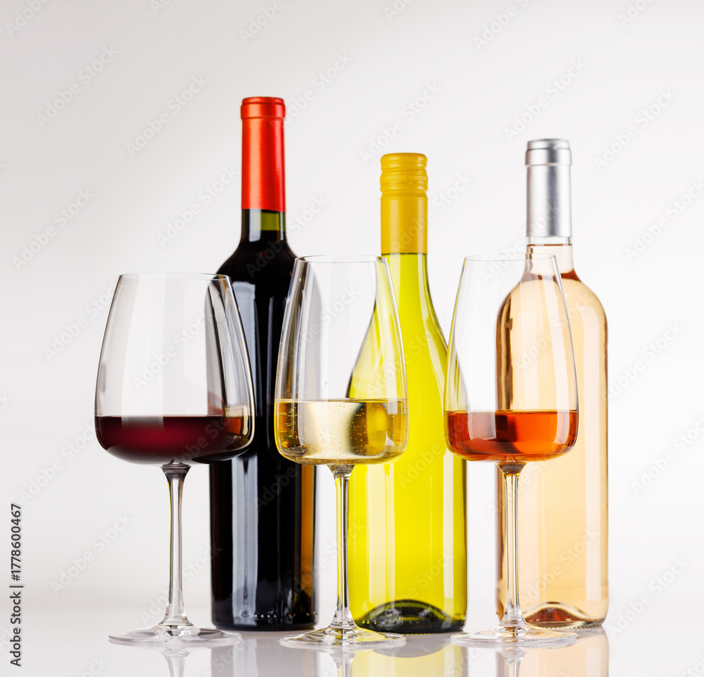 Fototapeta premium Different wine bottles and glasses on white background