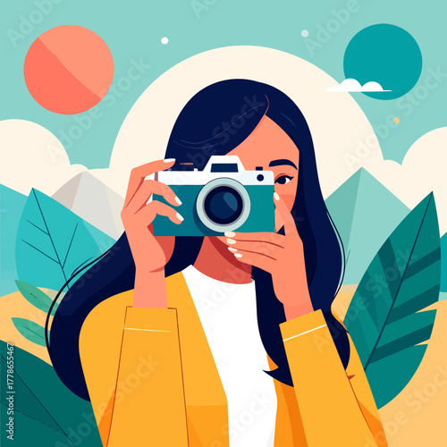 A stylish woman with long dark hair in a yellow jacket holding a vintage teal camera to her eye.