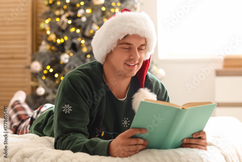 Young man in Santa hat read...