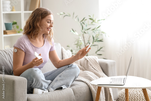 Diabetic young woman with glucometer and lancet pen talking to doctor online ...